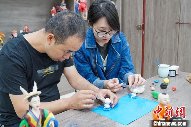 <a target='_blank'  data-cke-saved- >中新社</a>記者(右)現(xiàn)場體驗(yàn)面塑制作過程。　陳爭強(qiáng) 攝