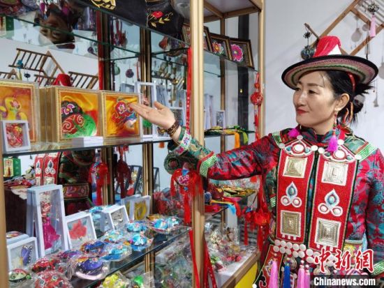 圖為身著民族服飾的隴原巧手展示手工藝品。(資料圖) 徐雪 攝