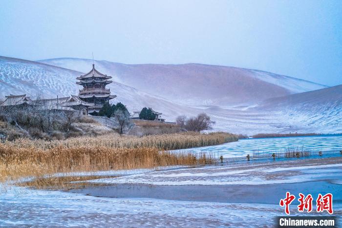 2021年11月28日，雪落鳴沙山月牙泉景區(qū)?！⊥醣筱y 攝