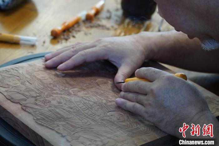 圖為徐晉林湊近木板，近距離制作雕版畫?！【琶赖┰?　攝