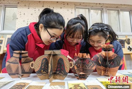 圖為學(xué)生用紙創(chuàng)作的立體彩陶?！⒂裉?攝