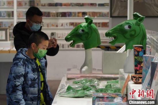 圖為“神馬來了”銅奔馬頭套吸引參觀者駐足?！【琶赖┰?攝