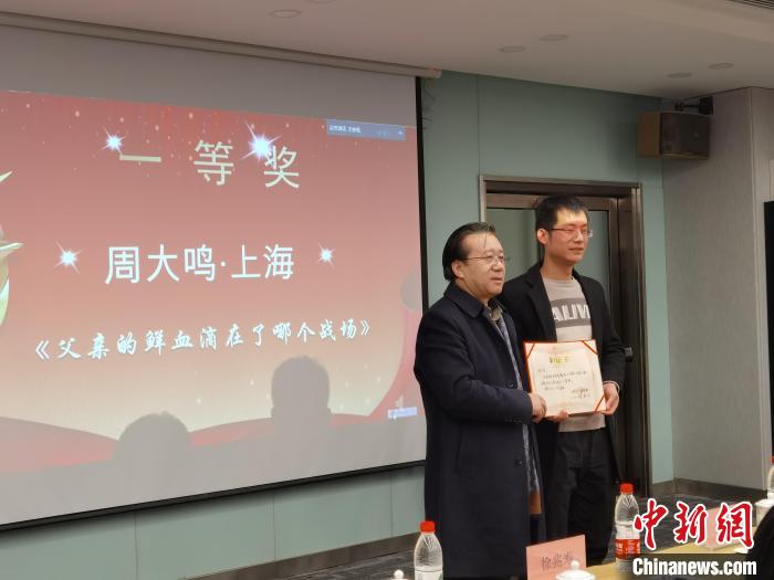 圖為作家、西北師范大學新聞與傳媒學院院長徐兆壽頒發(fā)一等獎證書，代領(lǐng)獎?wù)呱吓_領(lǐng)獎。　楊娜 攝