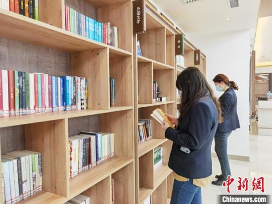 圖為在甘肅公航旅建設(shè)集團有限公司的職工書屋，職工挑選書籍?！⌒煅?攝