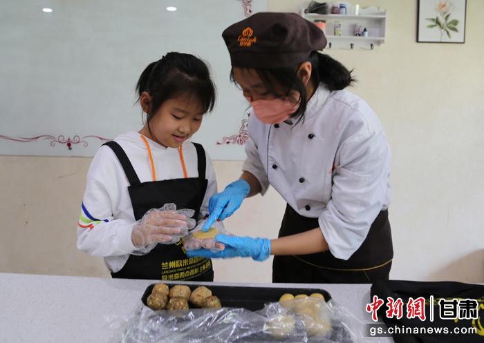 圖為在甘臺(tái)胞小朋友在工作人員指導(dǎo)下制作月餅。九美旦增 攝