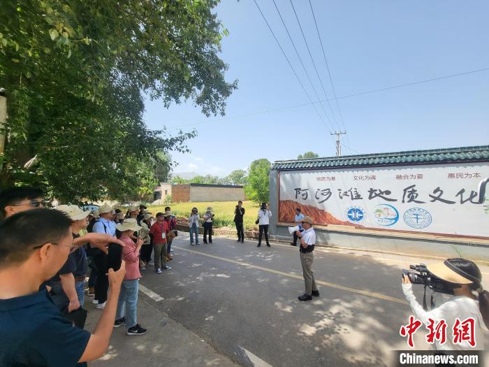 圖為中國地質(zhì)大學(北京)教授張緒教介紹村落情況?！『衍?攝