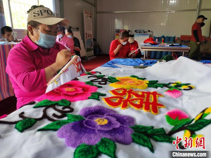 圖為婦女制作青繡?！?zhí)砀?攝