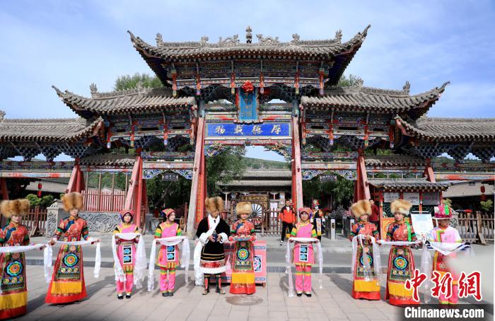 圖為身穿土族服飾的工作人員迎接訪客?！⊙Φ?攝