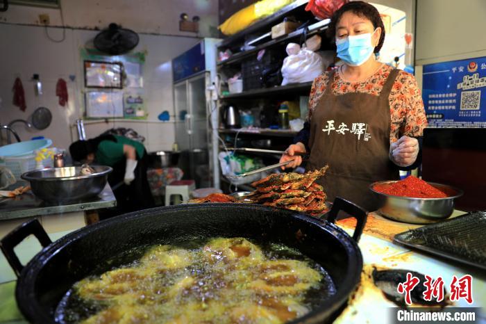 圖為平安驛·河湟民俗文化體驗地內的商戶炸干板魚?！⊙Φ?攝