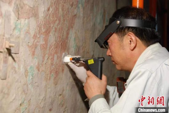 敦煌研究院研究員樊再軒進行壁畫修復(fù)。(資料圖)張云文 攝