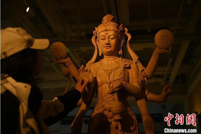 圖為季茂杰觀察自己創(chuàng)作的敦煌木雕。李亞龍 攝</p>
<p>