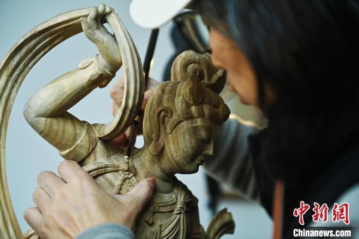 圖為季茂杰進行敦煌元素的木雕創(chuàng)作。李亞龍 攝</p>
<p>