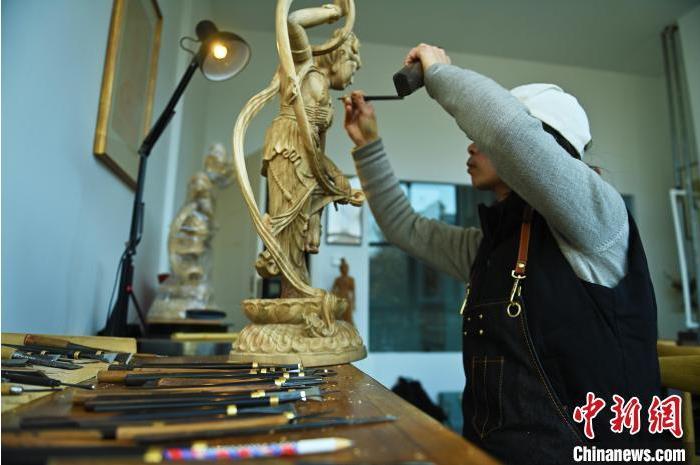 圖為季茂杰進行敦煌元素的木雕創(chuàng)作。李亞龍 攝</p>
<p>