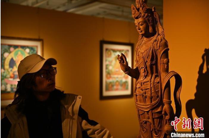 圖為季茂杰觀察自己創(chuàng)作的敦煌木雕。李亞龍 攝</p>
<p>
