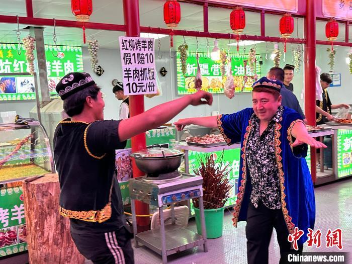 圖為餐飲經(jīng)營者在“西涼不夜城”跳起舞蹈引客?！〈魑牟?攝</p><p>