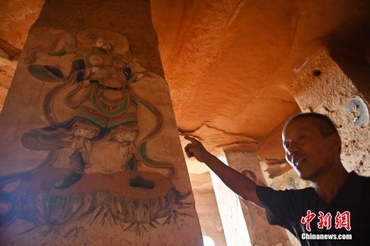 7月15日，甘肅省平?jīng)鍪袥艽h百里石窟長廊羅漢洞石窟內(nèi)，該窟文保員郭建平介紹窟內(nèi)石刻彩繪壁畫。郭建平家中三代人曾自發(fā)保護羅漢洞石窟。羅漢洞石窟遺存40余個窟龕，以北魏至清代風格為主。中新社記者 李亞龍 攝</p>
<p>