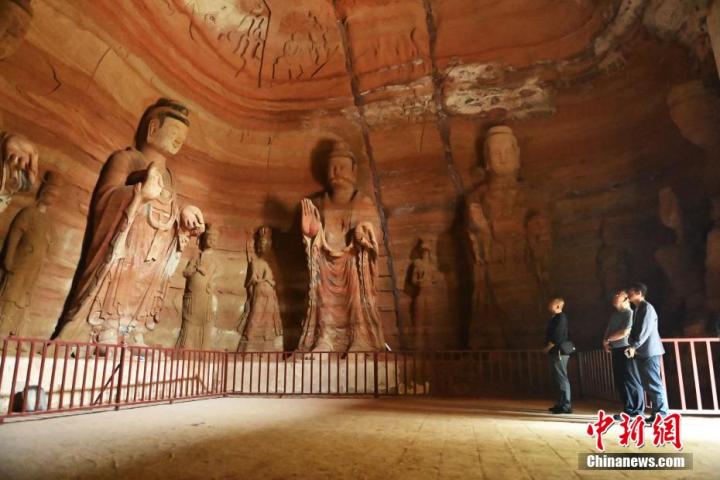 7月15日，游人參觀甘肅省平?jīng)鍪袥艽h百里石窟長廊中的南石窟寺1號窟。百里石窟長廊位于涇川縣境內(nèi)，由512個石窟、5眼窟中石井組成，現(xiàn)存王母宮石窟、鳳凰山石窟、南石窟寺、丈八寺石窟、羅漢洞石窟、太山寺石窟等規(guī)模較大的石窟群，還有數(shù)量眾多的小石窟群。南石窟寺開鑿于北魏永平三年，其中1號窟屬于大型七佛窟，七佛高達6米。中新社記者 李亞龍 攝