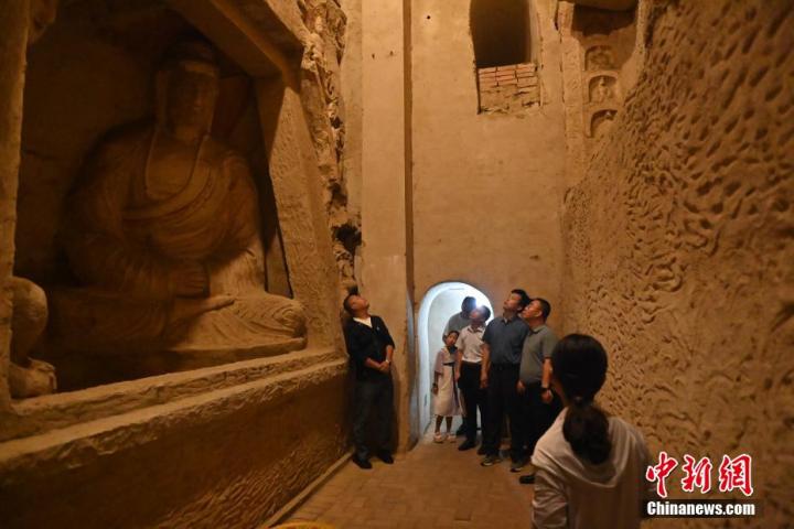 7月15日，游人參觀甘肅省平?jīng)鍪袥艽h百里石窟長廊中的王母宮石窟。百里石窟長廊位于涇川縣境內(nèi)，由512個石窟、5眼窟中石井組成，現(xiàn)存王母宮石窟、鳳凰山石窟、南石窟寺、丈八寺石窟、羅漢洞石窟、太山寺石窟等規(guī)模較大的石窟群，還有數(shù)量眾多的小石窟群。王母宮石窟又名千佛洞，該窟設計宏大，造像生動，窟內(nèi)擁有造像數(shù)百尊，是較為珍貴的佛教文化歷史遺存。中新社記者 李亞龍 攝</p>
<p>