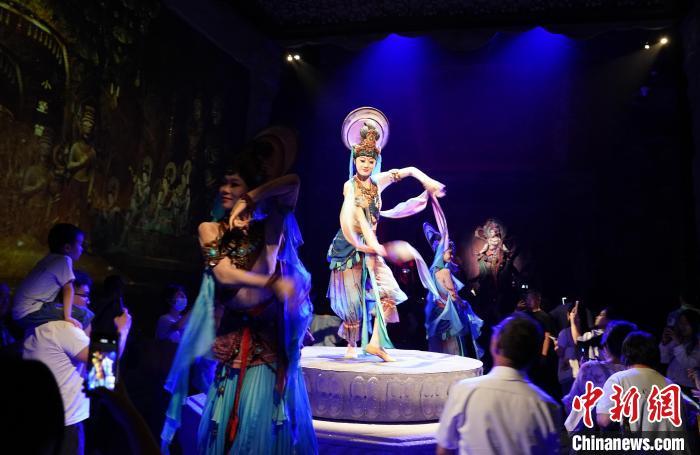 《樂動敦煌》是全球首部洞窟式沉浸體驗劇，利用真人與數字影像虛實交換實現沉浸式體驗。圖為2023年8月28日晚，《樂動敦煌》演出。(資料圖)中新社記者 毛建軍 攝