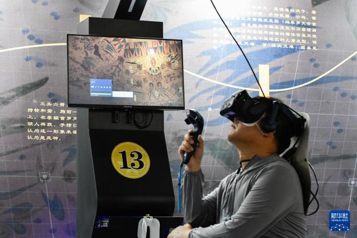 7月22日，游客借助VR設(shè)備沉浸式游覽莫高窟第285窟虛擬場景。新華社記者 郎兵兵 攝